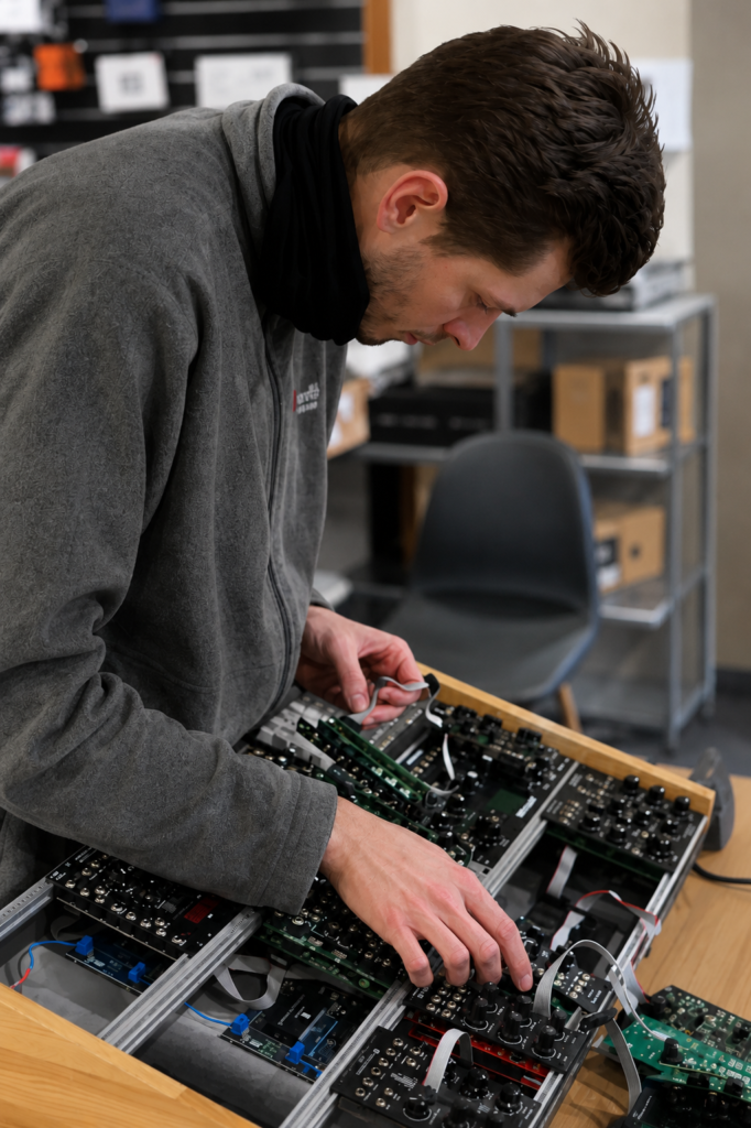 Electronics technician assembling and testing circuit boards in a professional engineering workshop