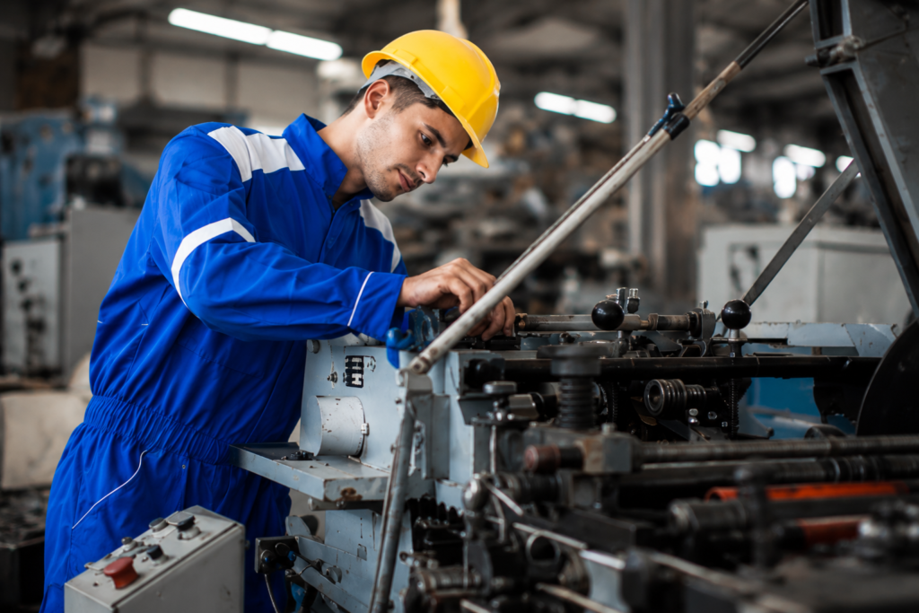 Mechanical engineer adjusting industrial machinery on factory floor - ANZSCO 233512