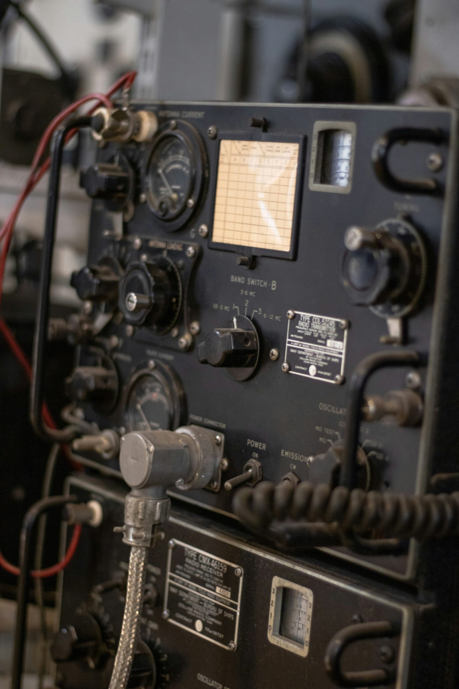 Telecommunications officer using a handheld radio to coordinate communication operations at an industrial site.